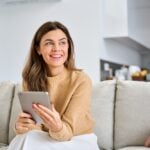 Sheridan’s Trusted HVAC Experts For Over 40 Years 3 Smiling woman holding a tablet